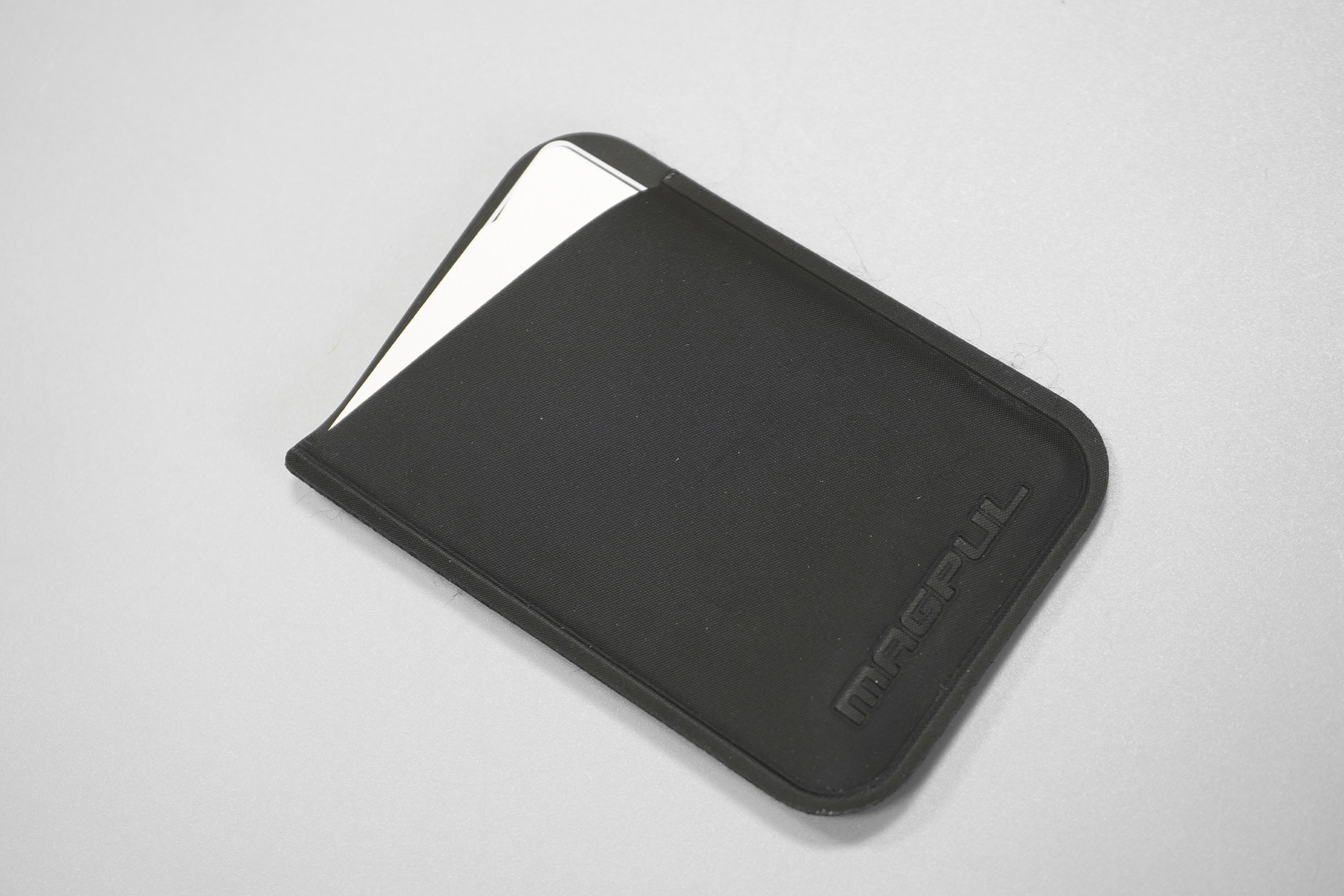 Magpul DAKA Micro Wallet | The debossed logo and polymer fabric, with some fraying at the edges.