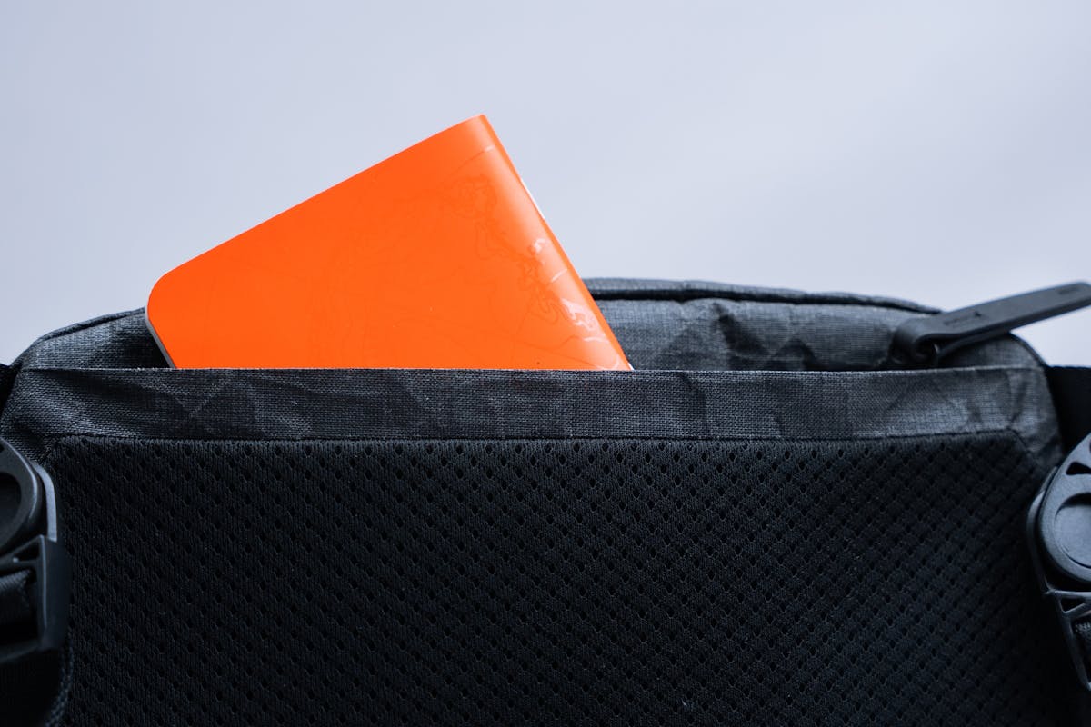 A notebook in the Pack Hacker x Aer Ultra Sling back zippered pocket